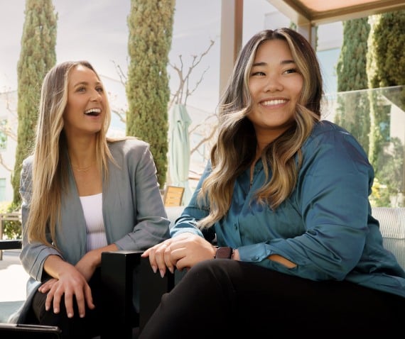 two women sitting and smiling at work