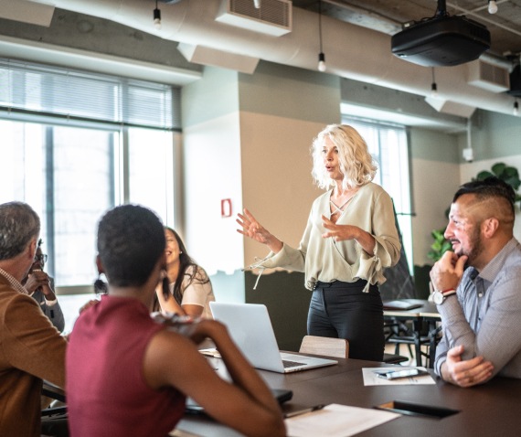 women speaking to office group