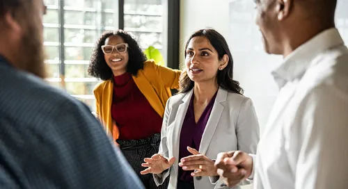 Woman having a conversation with a group in the office