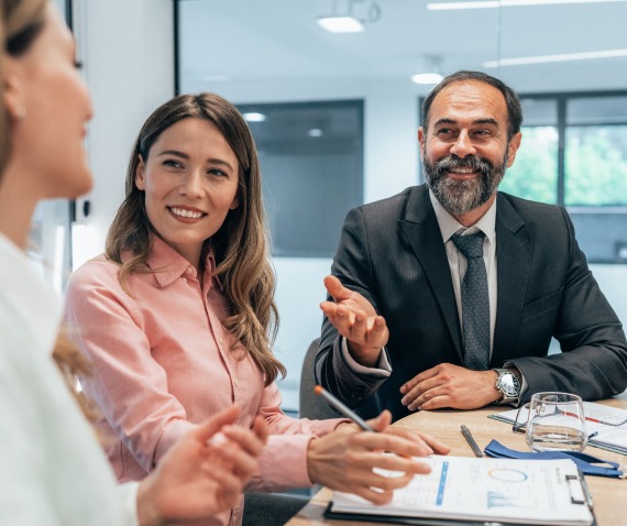 three people having a meeting in an office