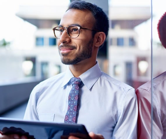 man with tie holding iPad