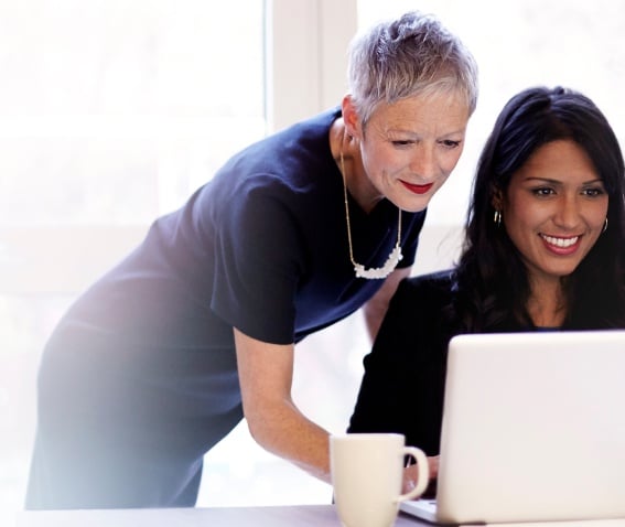 A coach working with an individual on their laptop