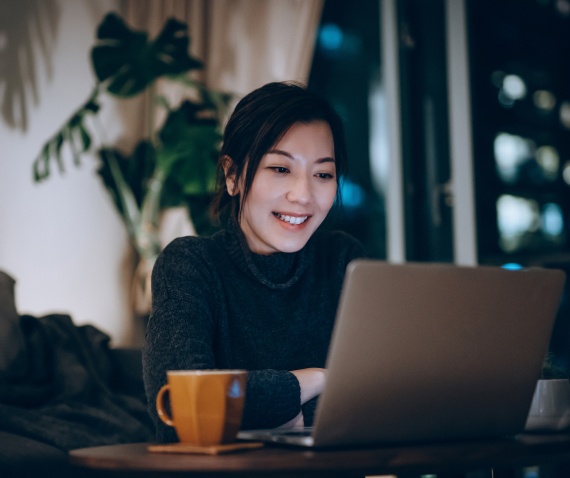 women working over laptop with coffee cup