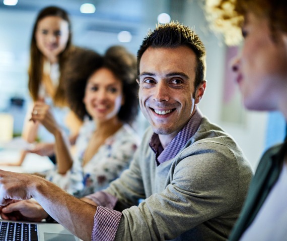 Smiling man in conversation with three others