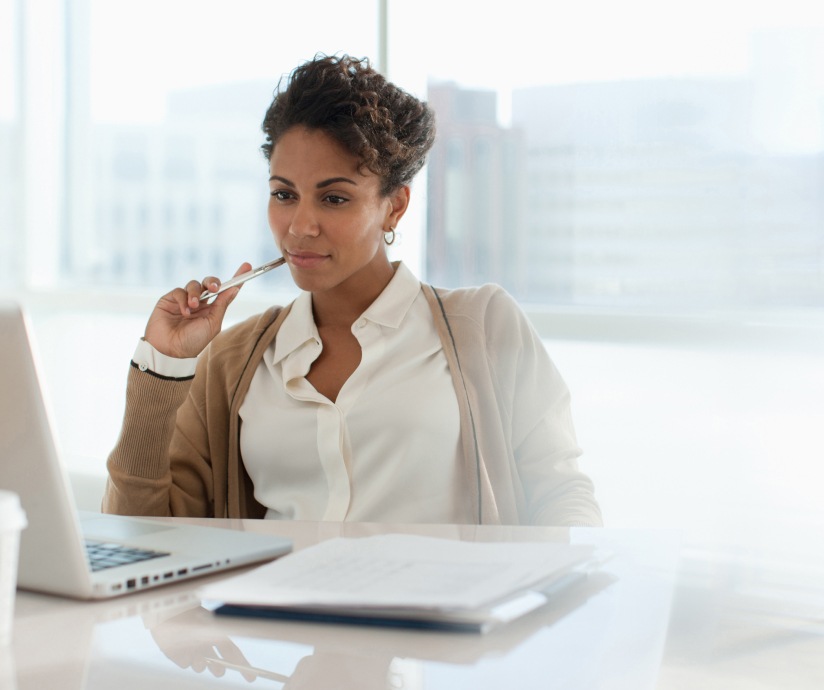 women thinking and looking at laptop